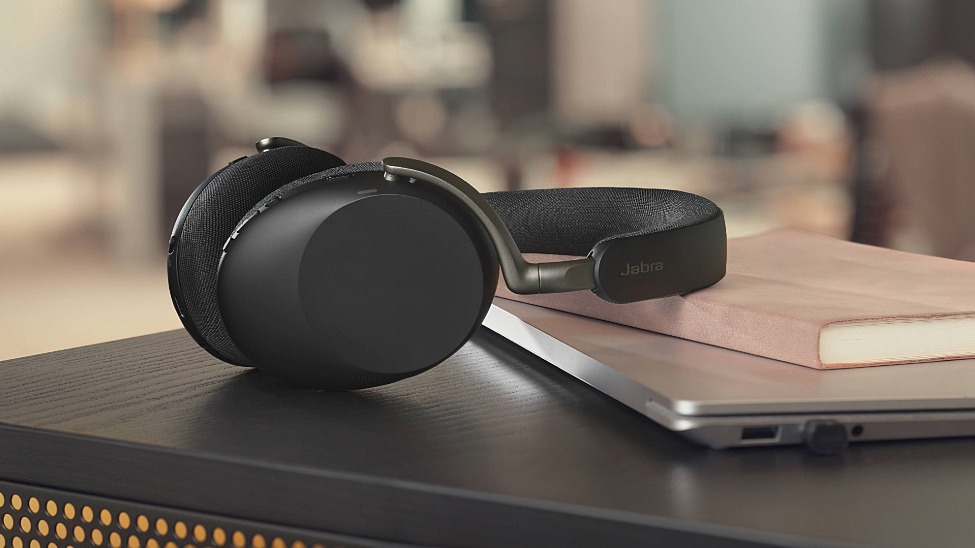 headset lying on top of notebook and laptop on desk